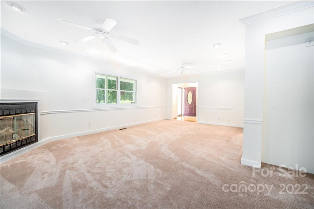 7720 Kinross Drive Oak Ridge, NC 27310 - Photo 13 of 42 an empty room with windows and fireplace