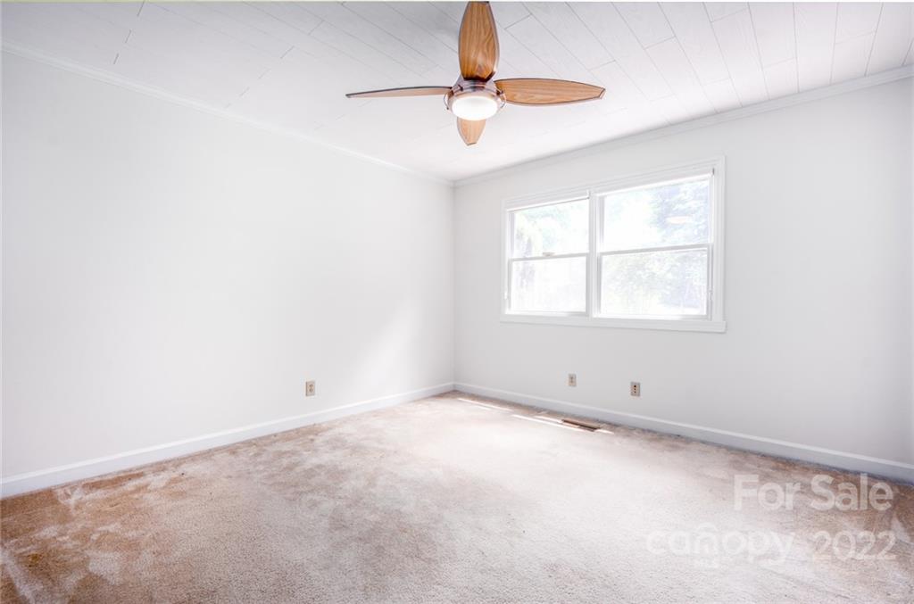 7720 Kinross Drive Oak Ridge, NC 27310 - Photo 16 of 42 an empty room with windows and fan