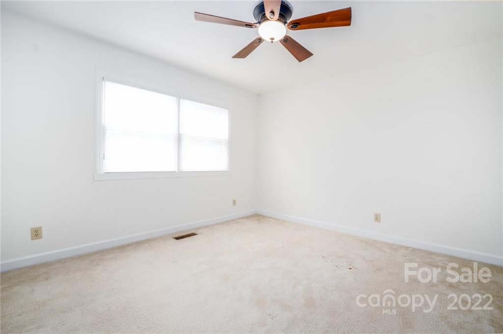 7720 Kinross Drive Oak Ridge, NC 27310 - Photo 18 of 42 an empty room with a window and a fan