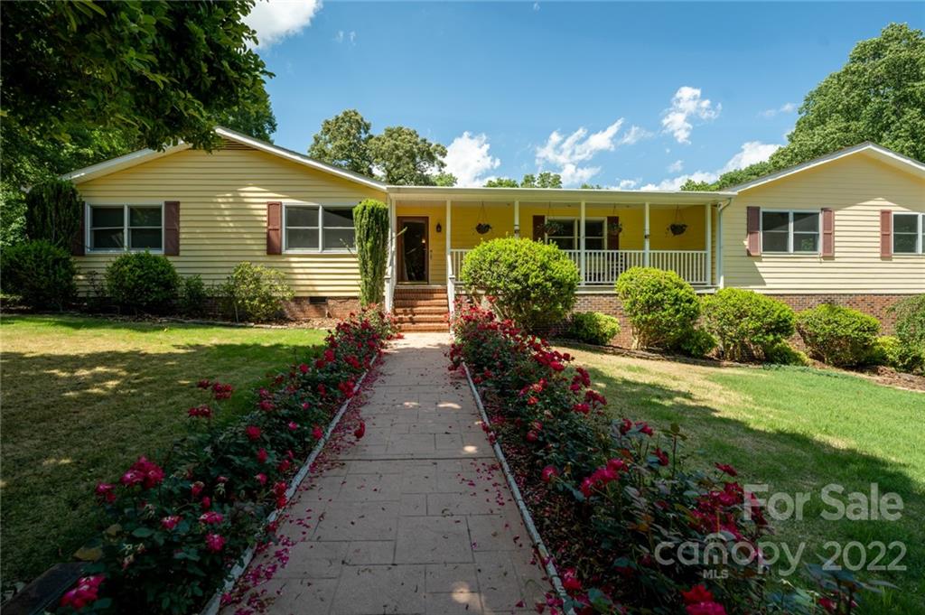 7720 Kinross Drive Oak Ridge, NC 27310 - Photo 2 of 42 a front view of a house with a yard and potted plants