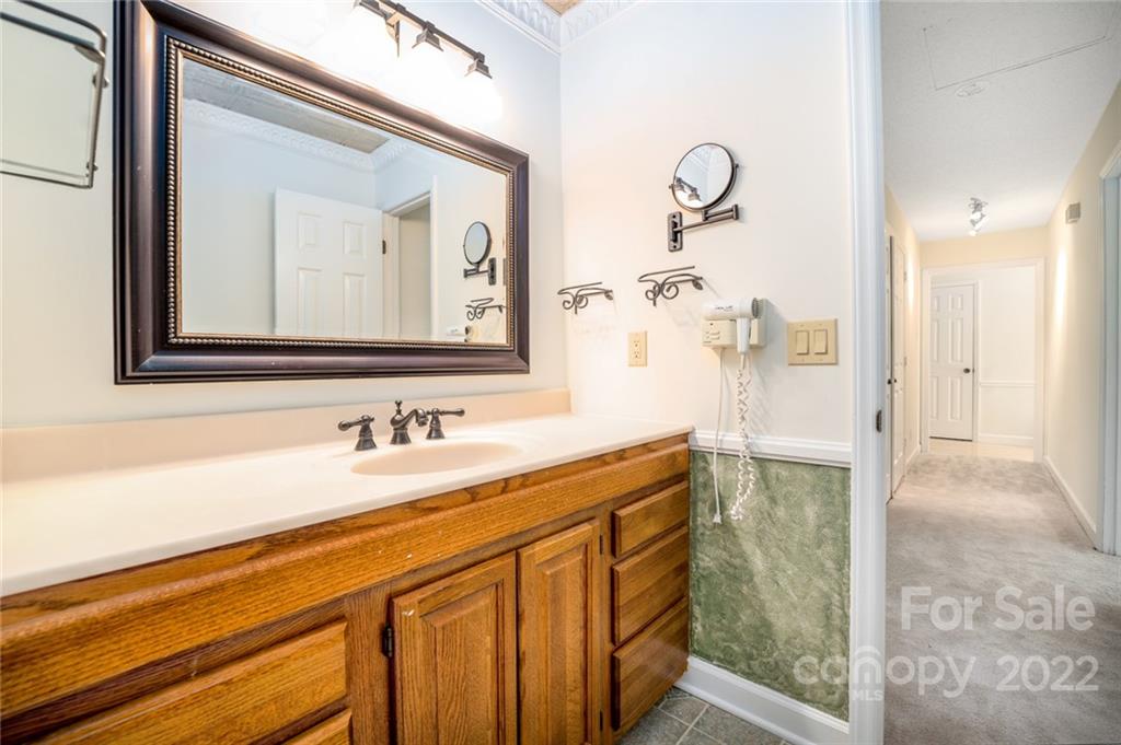 7720 Kinross Drive Oak Ridge, NC 27310 - Photo 21 of 42 a bathroom with a sink a mirror and a shower