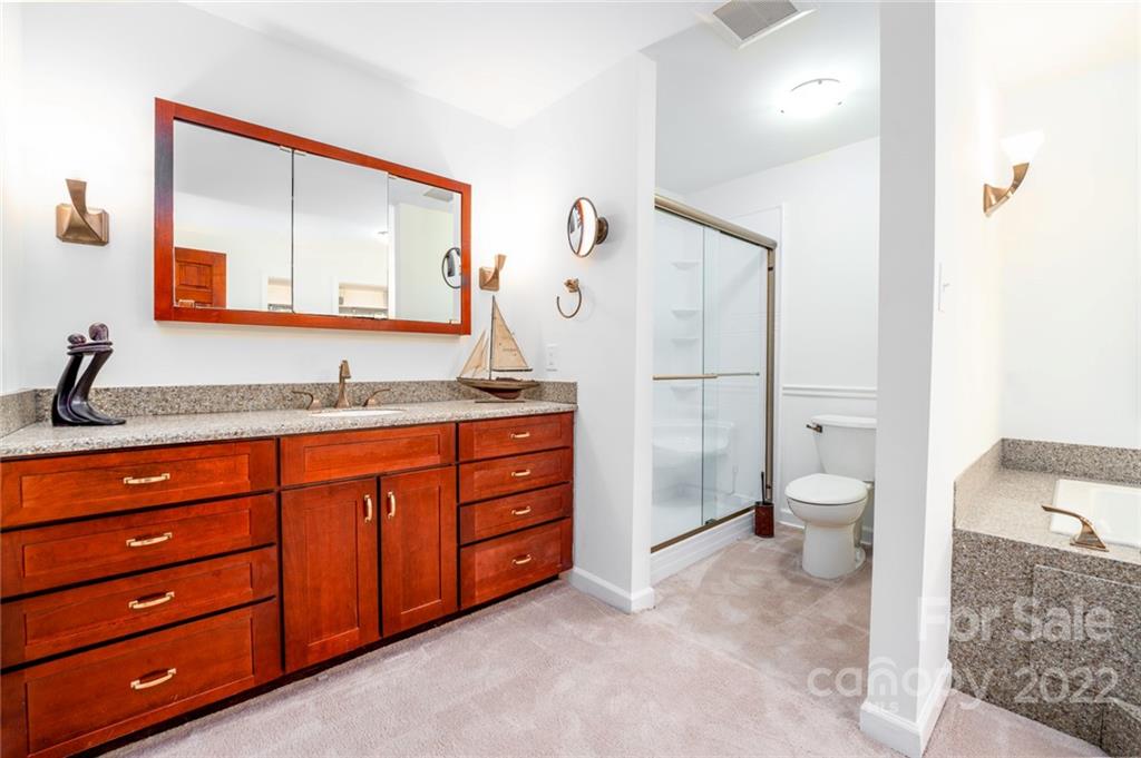 7720 Kinross Drive Oak Ridge, NC 27310 - Photo 24 of 42 a spacious bathroom with a granite countertop sink toilet and a mirror