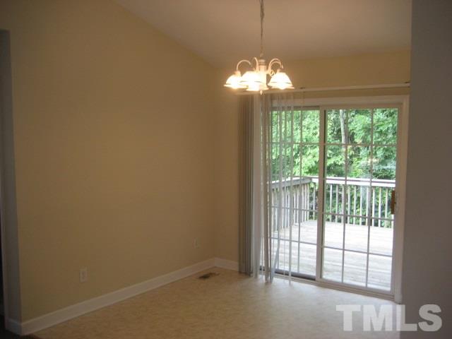 3205 Stedman Drive Raleigh, NC 27607 - Photo 5 of 10 a view of a livingroom with a chandelier curtains and large windows