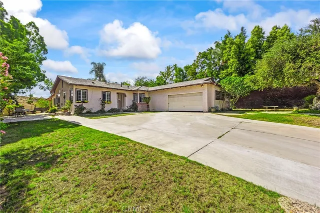 a view of an house with backyard and trees