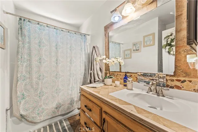 a bathroom with a granite countertop sink and a mirror