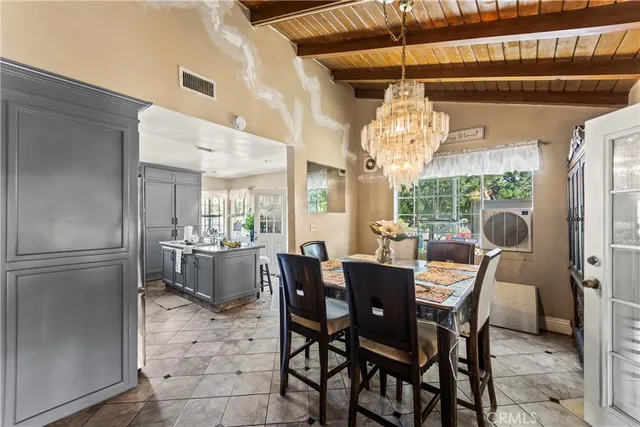 a dining room with furniture a chandelier and window