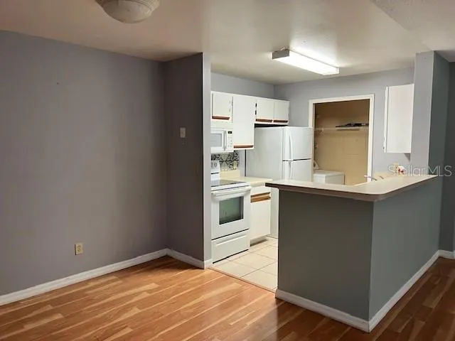 a kitchen with a refrigerator and white cabinets