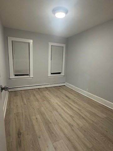 166 A Chelsea Street, Unit 1 Boston, MA 02128 - Photo 4 of 13 an empty room with wooden floor and windows