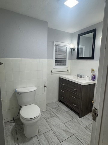 166 A Chelsea Street, Unit 1 Boston, MA 02128 - Photo 7 of 13 a bathroom with a toilet sink vanity and mirror