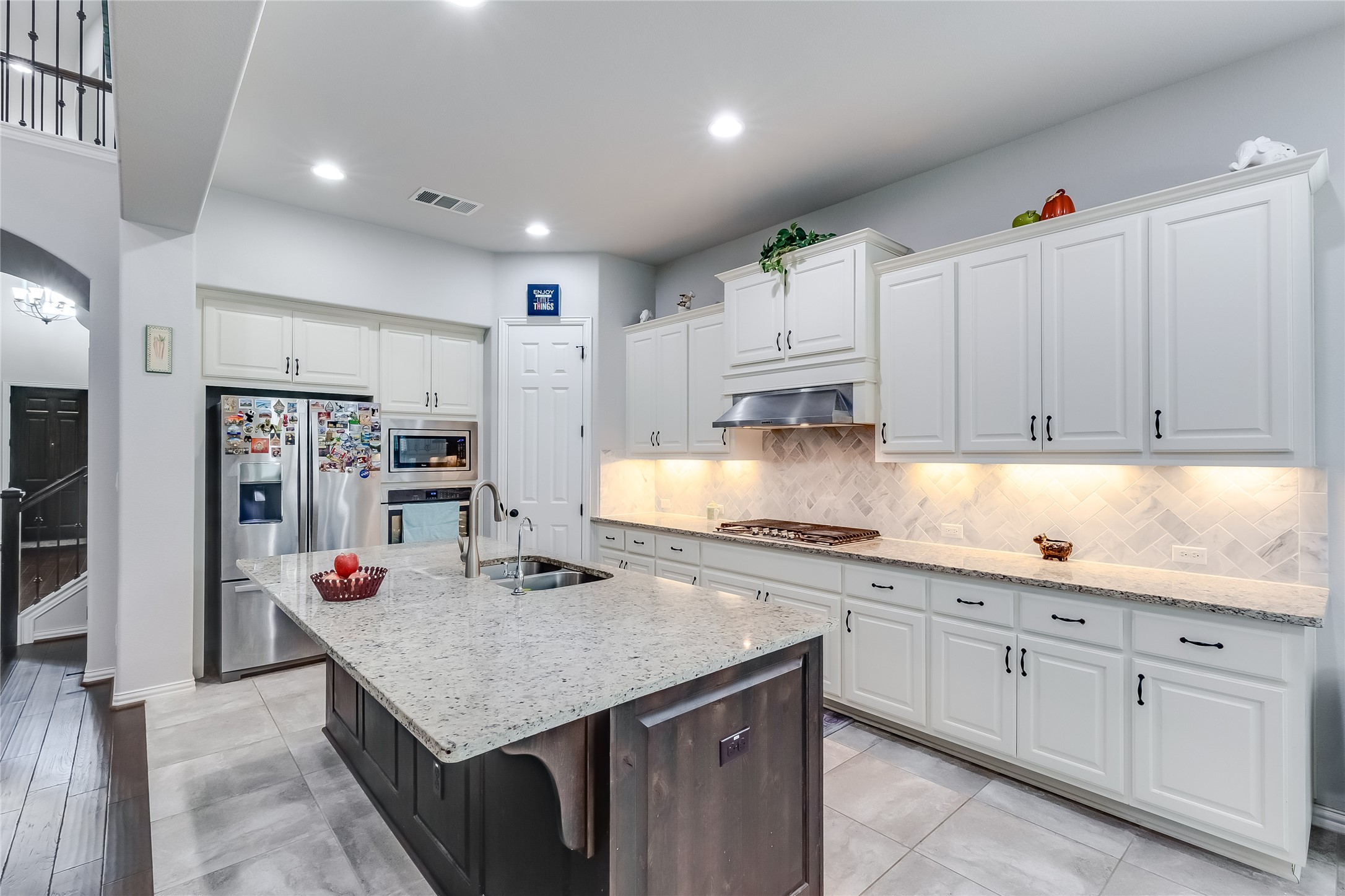 204 Lady Bird Lane Georgetown, TX 78628 - Photo 12 of 40 a kitchen with stainless steel appliances kitchen island granite countertop a sink dishwasher and cabinets with wooden floor