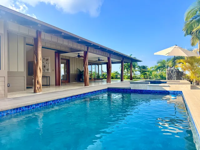 a view of swimming pool with lawn chairs under an umbrella