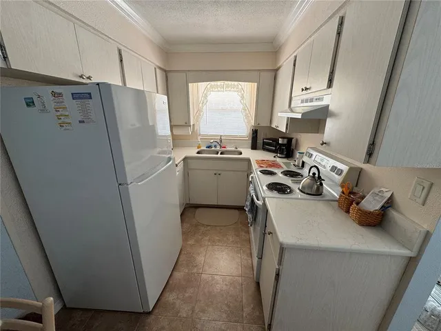 a kitchen with a refrigerator a stove a sink and a window