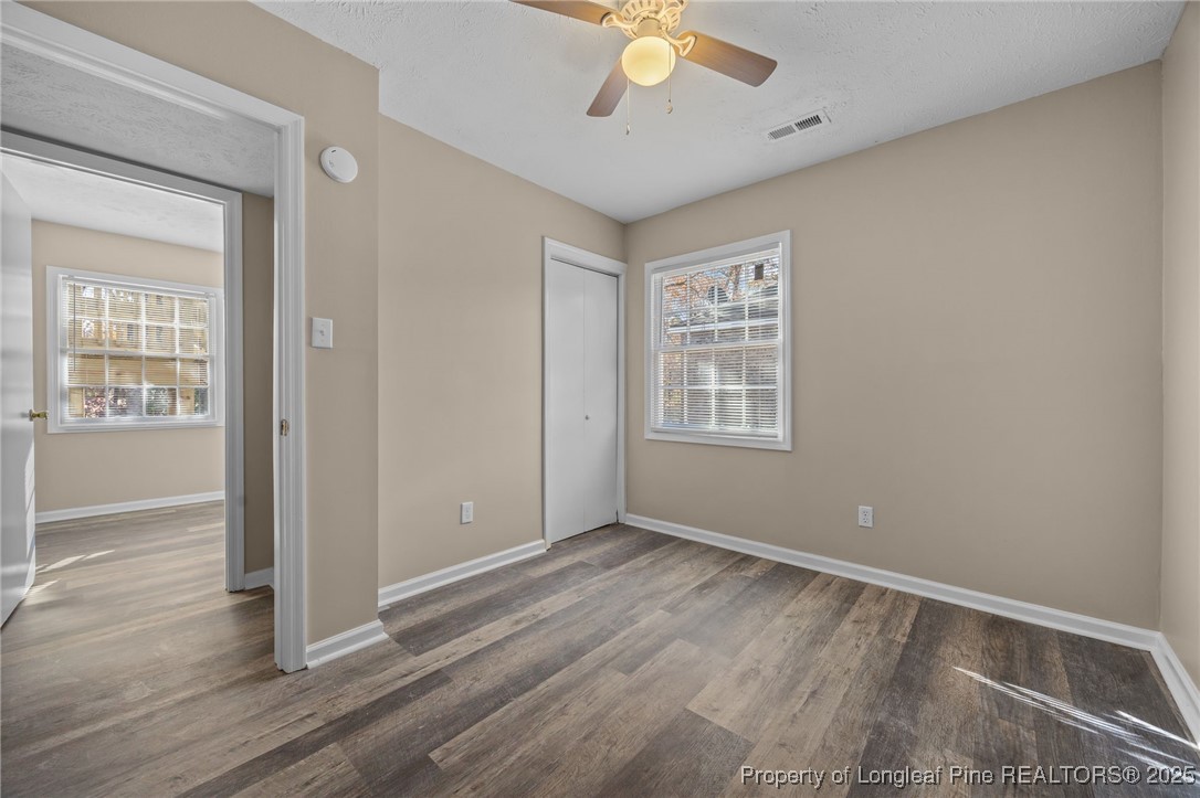 735 Ashbrook Road Fayetteville, NC 28314 - Photo 16 of 39 an empty room with wooden floor fan and windows