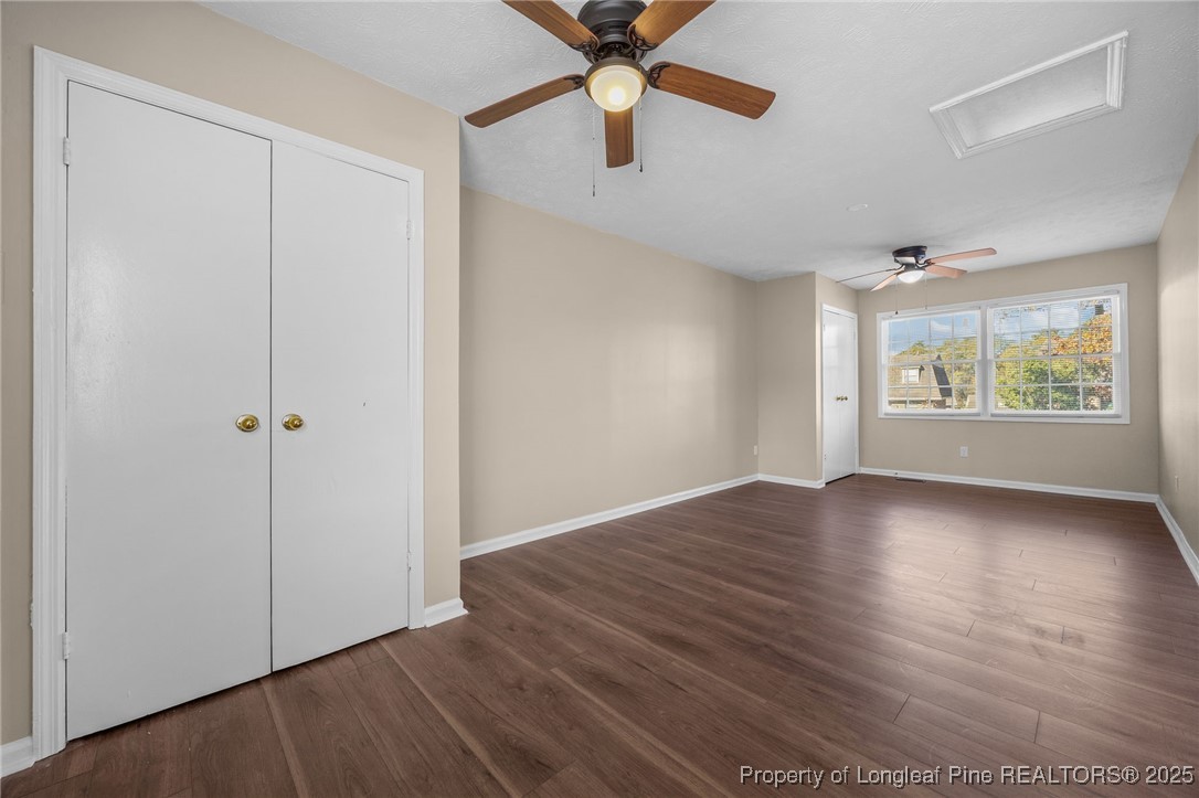 735 Ashbrook Road Fayetteville, NC 28314 - Photo 22 of 39 an empty room with wooden floor chandelier fan and windows