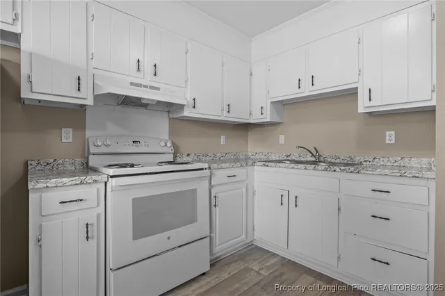 a kitchen with granite countertop white cabinets and white appliances