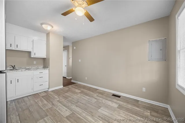 a room with a granite countertop cabinets and wooden floor
