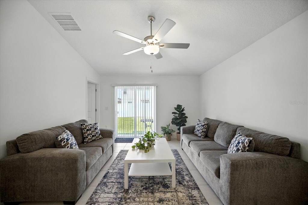 73 Rain Lily Ave Spring Hill Spring Hill, FL 34609 - Photo 12 of 37 a living room with furniture and a chandelier