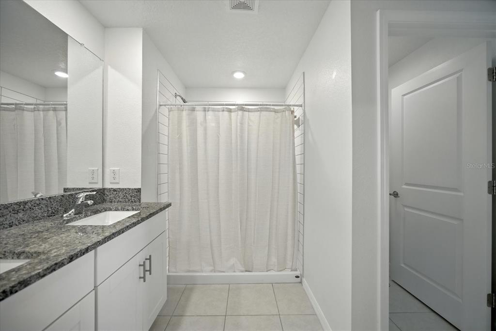 73 Rain Lily Ave Spring Hill Spring Hill, FL 34609 - Photo 19 of 37 a bathroom with a granite countertop sink and a mirror