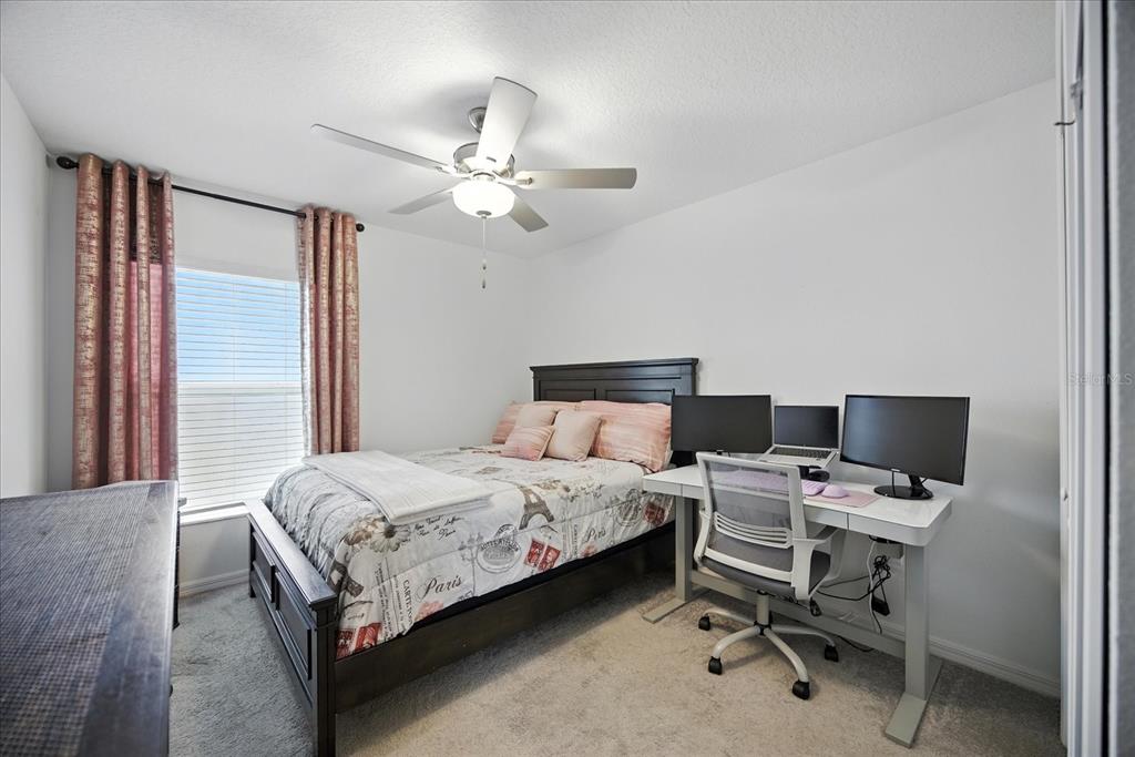 73 Rain Lily Ave Spring Hill Spring Hill, FL 34609 - Photo 22 of 37 a bedroom with a bed and a chandelier