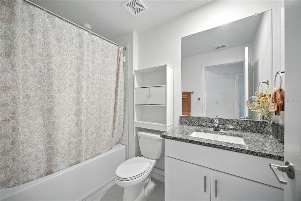 73 Rain Lily Ave Spring Hill Spring Hill, FL 34609 - Photo 26 of 37 a bathroom with a granite countertop sink and a mirror