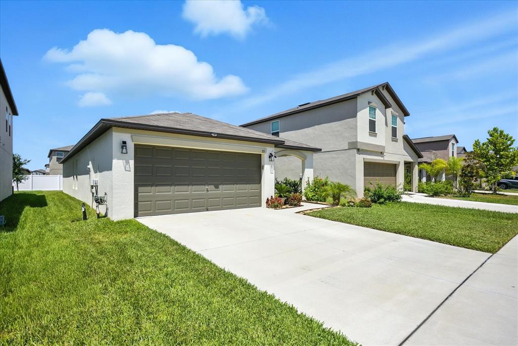 73 Rain Lily Ave Spring Hill Spring Hill, FL 34609 - Photo 4 of 37 a front view of a house with a yard and garage
