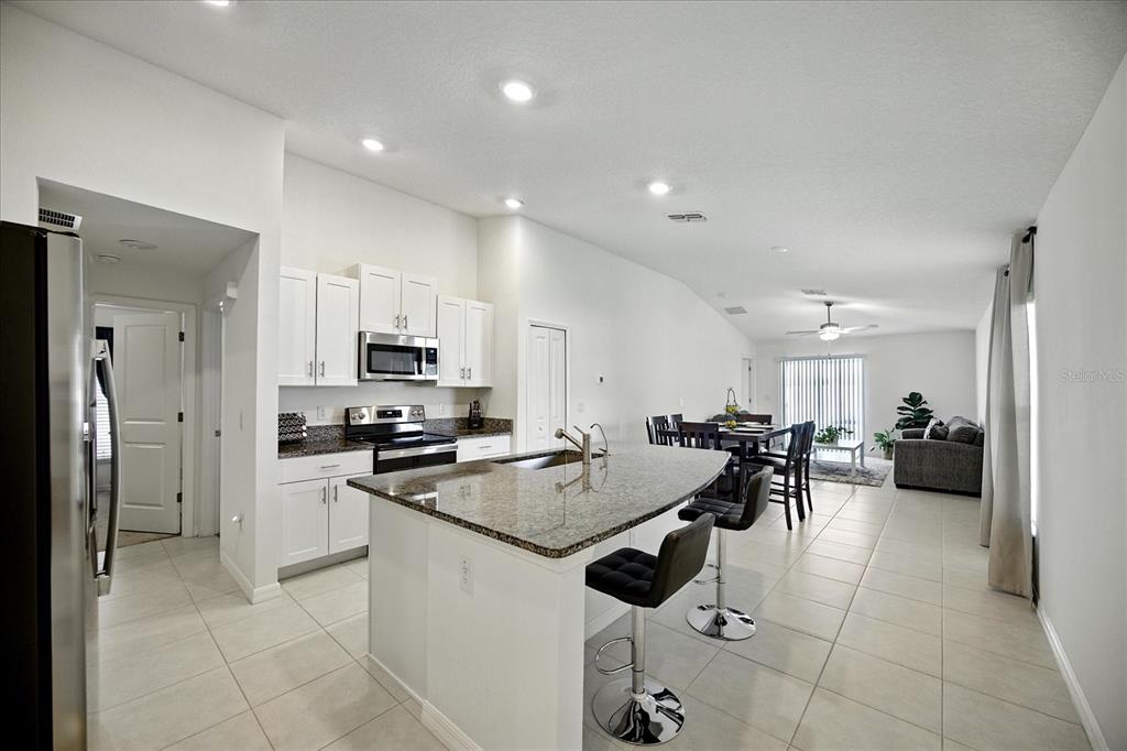 73 Rain Lily Ave Spring Hill Spring Hill, FL 34609 - Photo 6 of 37 a kitchen with a refrigerator and a stove top oven