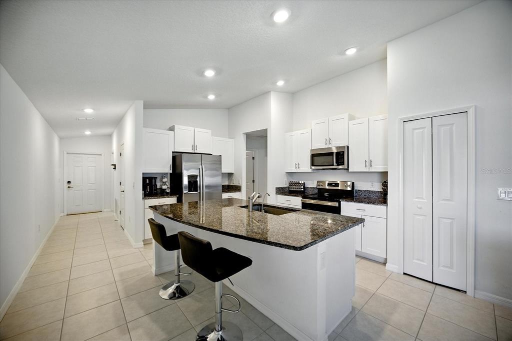 73 Rain Lily Ave Spring Hill Spring Hill, FL 34609 - Photo 7 of 37 a kitchen with stainless steel appliances granite countertop a stove a sink a refrigerator and a microwave