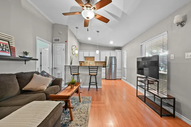 a living room with furniture and a wooden floor