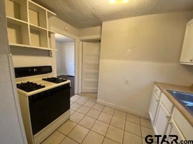 309 East Rix Street, Unit B Tyler, TX 75701 - Photo 6 of 9 a kitchen with a stove and a refrigerator