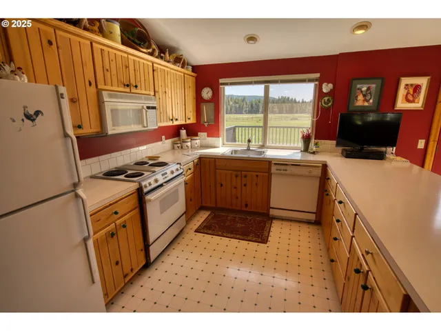 a view of kitchen with stainless steel appliances granite countertop a sink and cabinets