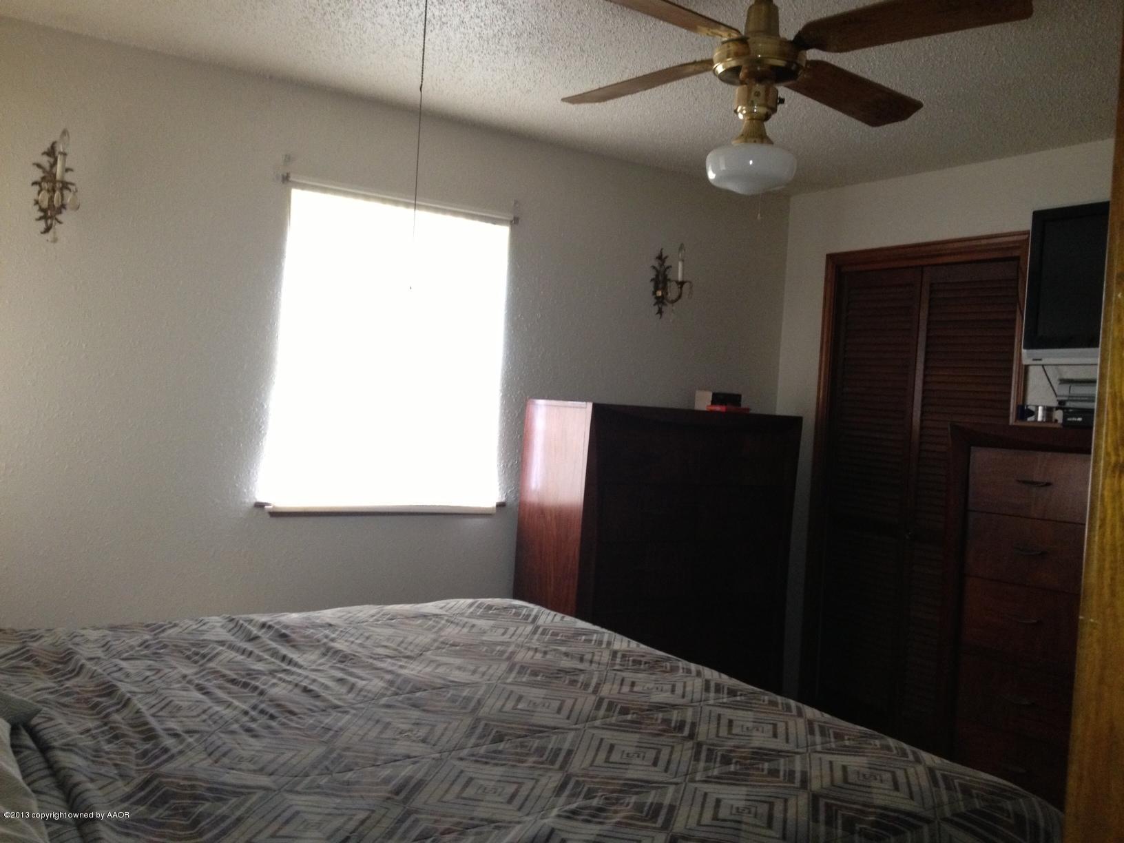 5106 Shield Drive Amarillo, TX 79110 - Photo 8 of 13 a bedroom with a bed and a chandelier