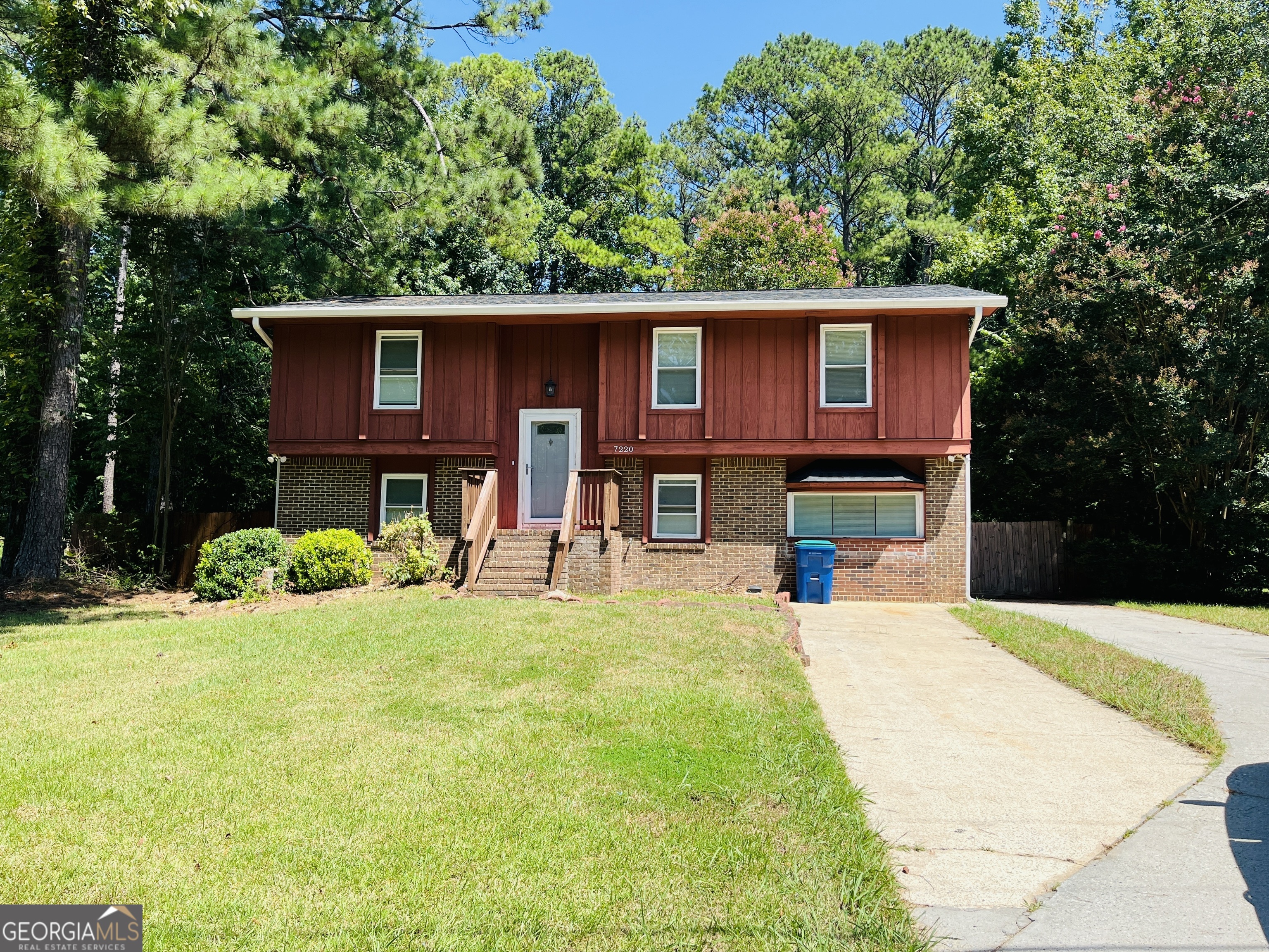 a view of a house with a yard patio and a tree