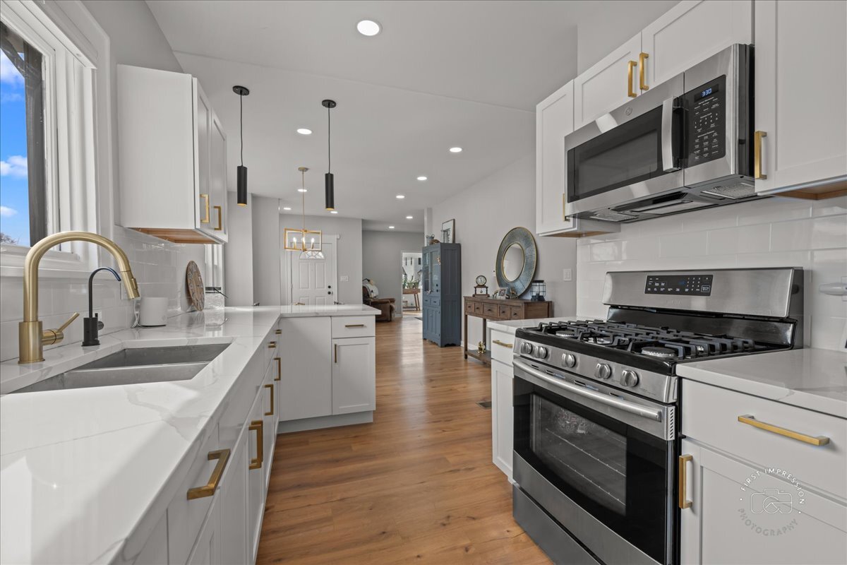 20 Central Avenue Aurora, IL 60506 - Photo 11 of 22 a kitchen with stainless steel appliances granite countertop a stove a sink and a microwave
