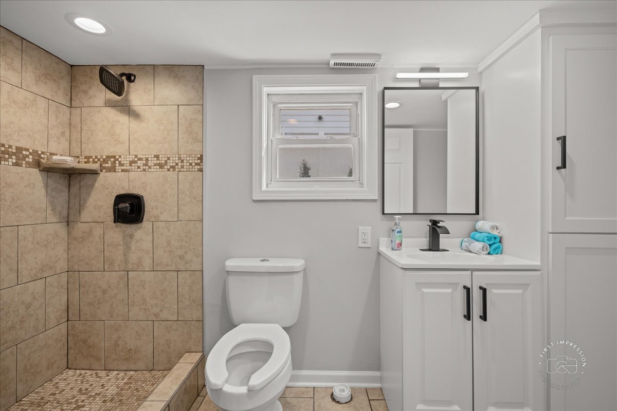 20 Central Avenue Aurora, IL 60506 - Photo 20 of 22 a bathroom with a toilet a sink a shower and mirror