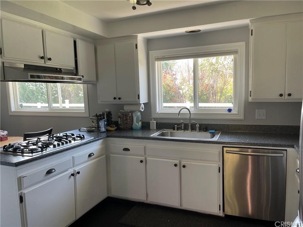5259 Lewis Road Agoura Hills, CA 91301 - Photo 25 of 39 a kitchen with granite countertop a refrigerator a sink and white cabinets