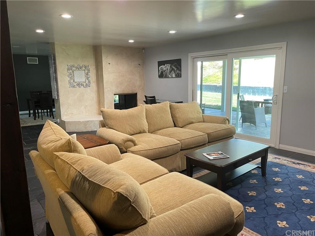 5259 Lewis Road Agoura Hills, CA 91301 - Photo 30 of 39 a living room with a fireplace and a painting on the wall