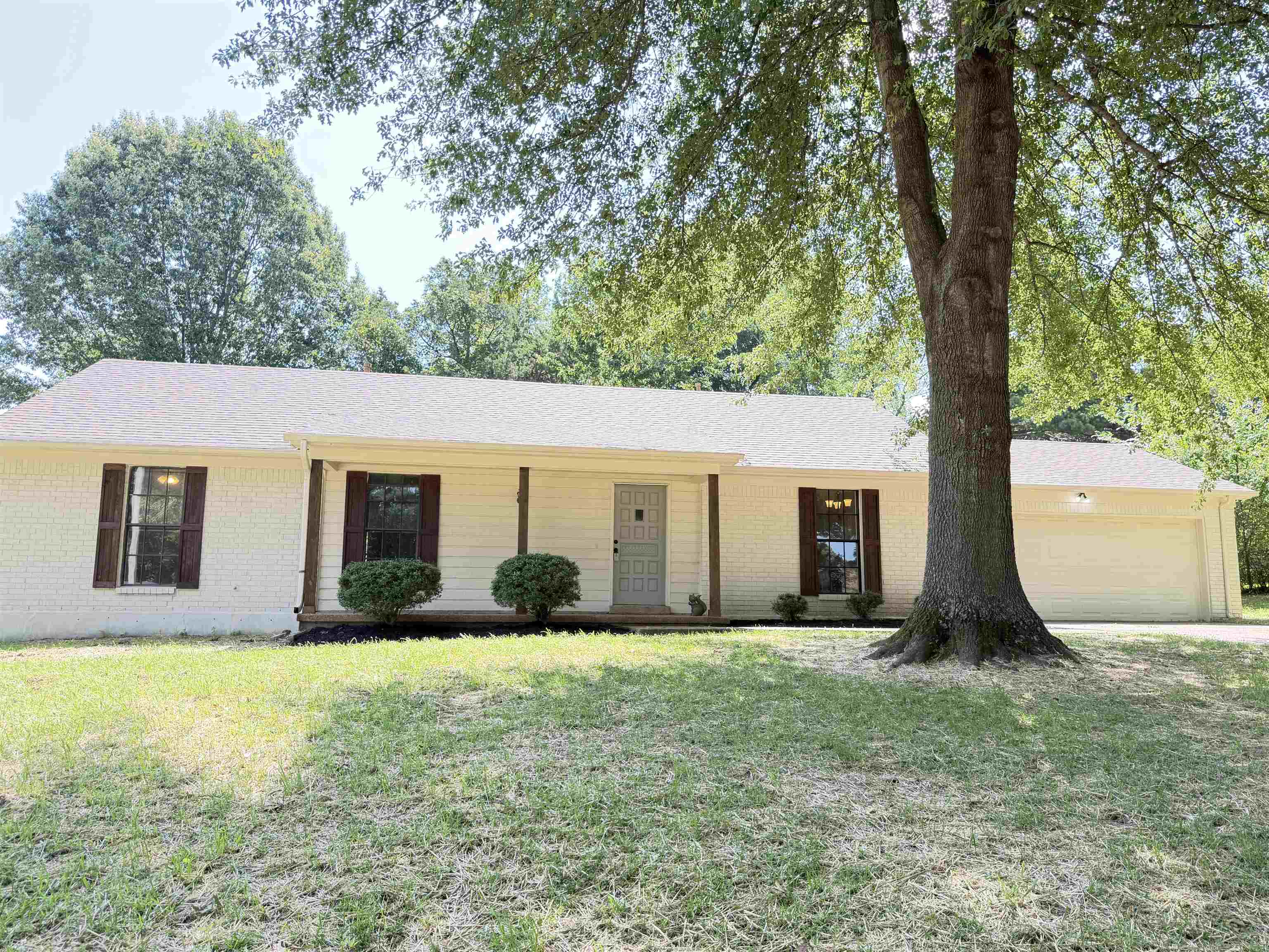 388 Park Hill Road Collierville, TN 38017 - Photo 1 of 19 Single-story residence featuring a light-colored brick facade, a covered front porch, and dark wood shutters