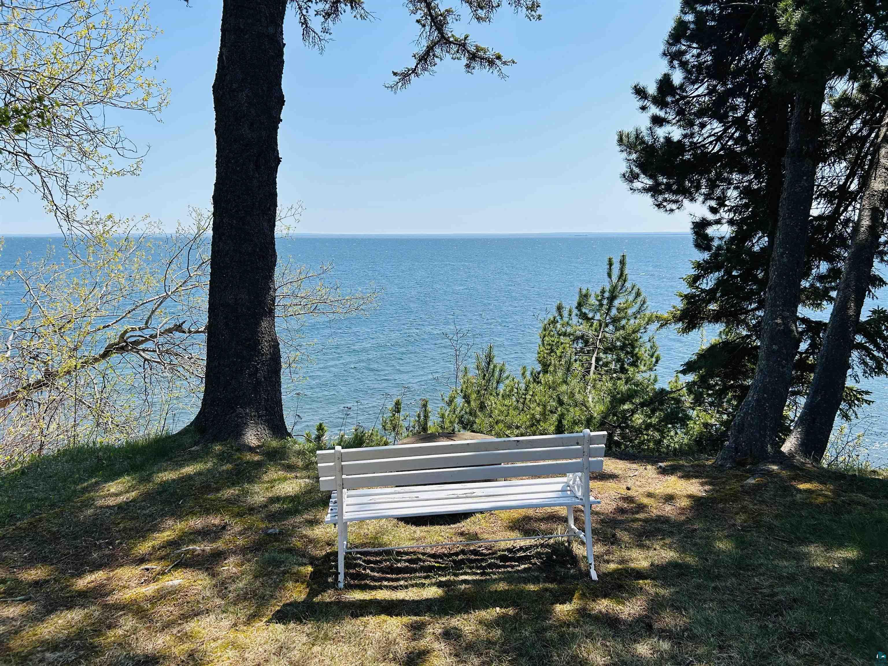 5090 London Road, Unit 1 Duluth, MN 55804 - Photo 50 of 54 Waterfront property with mature trees, a manicured lawn, and a white outdoor bench