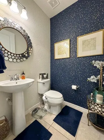 a bathroom with a toilet a sink a mirror and bathtub
