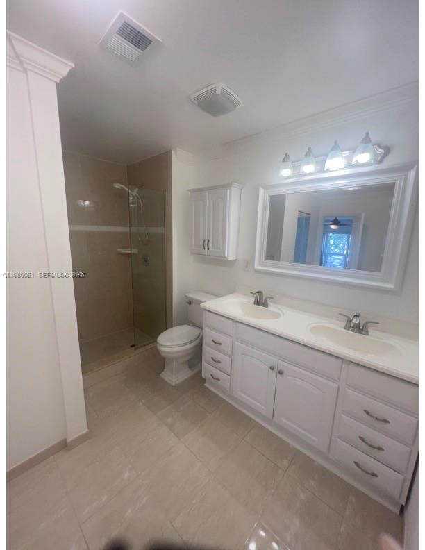 3302 Farragut Street, Unit 5F Hollywood, FL 33021 - Photo 4 of 11 a bathroom with a double vanity sink a toilet and a mirror