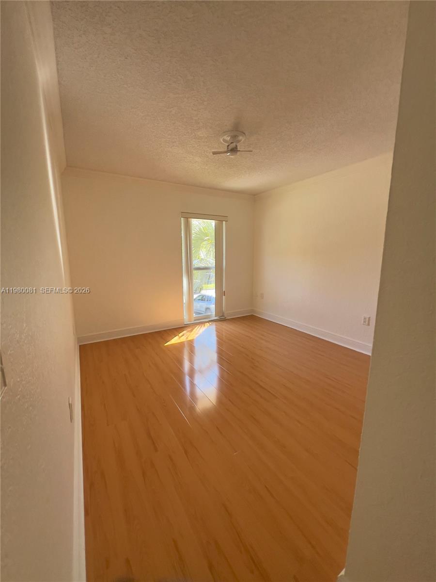 3302 Farragut Street, Unit 5F Hollywood, FL 33021 - Photo 9 of 11 an empty room with wooden floor and windows
