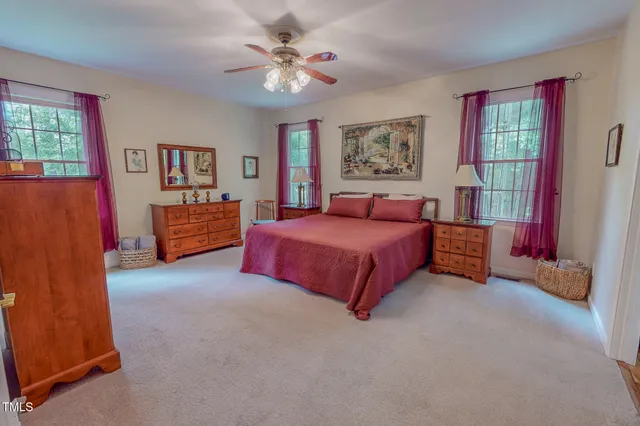a spacious bedroom with a bed and a chandelier