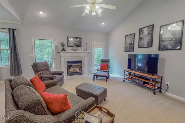 a living room with furniture a flat screen tv and a fireplace