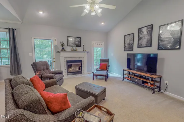 a living room with furniture a flat screen tv and a fireplace