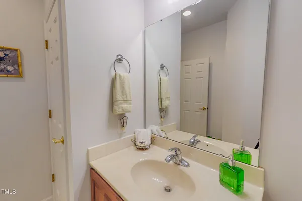 a view of a small house with potted plants and a car park side of a road