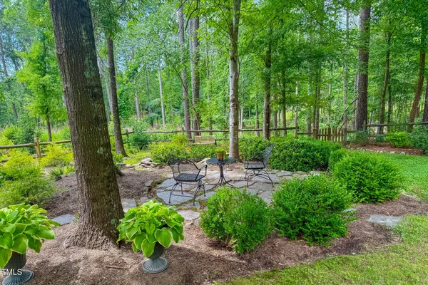 a backyard of a house with lots of green space and fountain