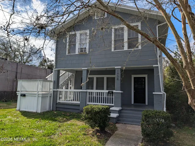 a view of a house with a small yard and wooden floor and fence