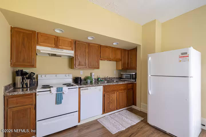 1438 Dancy Street Jacksonville, FL 32205 - Photo 14 of 49 a kitchen with a refrigerator a stove top oven a sink and cabinets