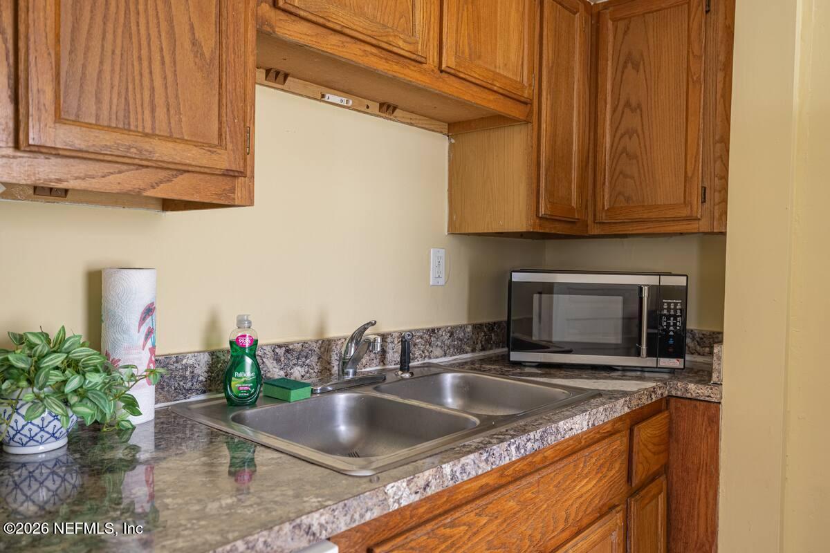 1438 Dancy Street Jacksonville, FL 32205 - Photo 15 of 49 a kitchen with a sink potted plants and cabinets
