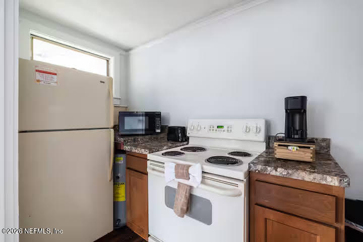 1438 Dancy Street Jacksonville, FL 32205 - Photo 34 of 49 a kitchen with a stove and white refrigerator